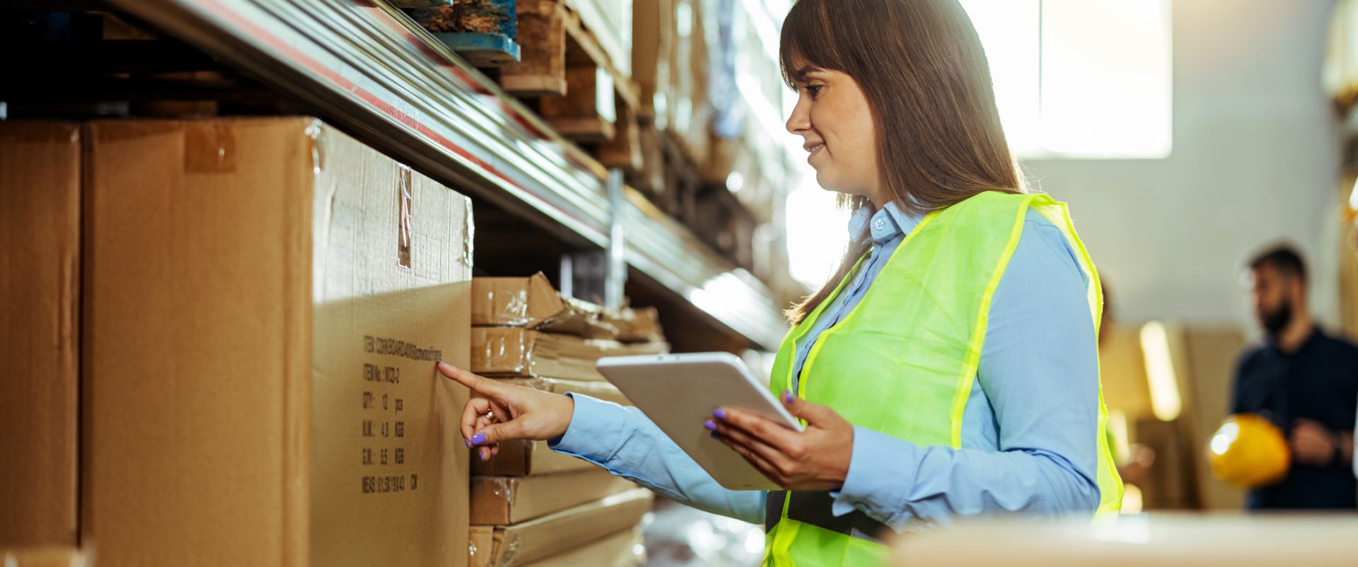 Woman inspecting factory shelves for supplier approval program.