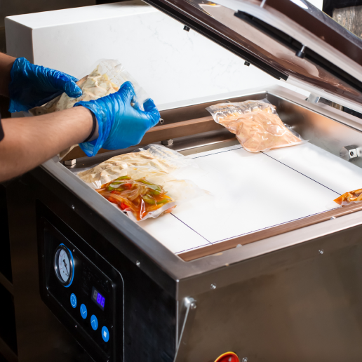 vacuum sealing packets of food while wearing gloves.