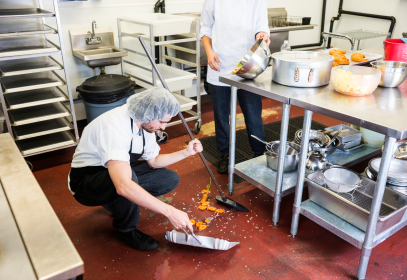 Sweeping up spilled ingredients at a food facility.