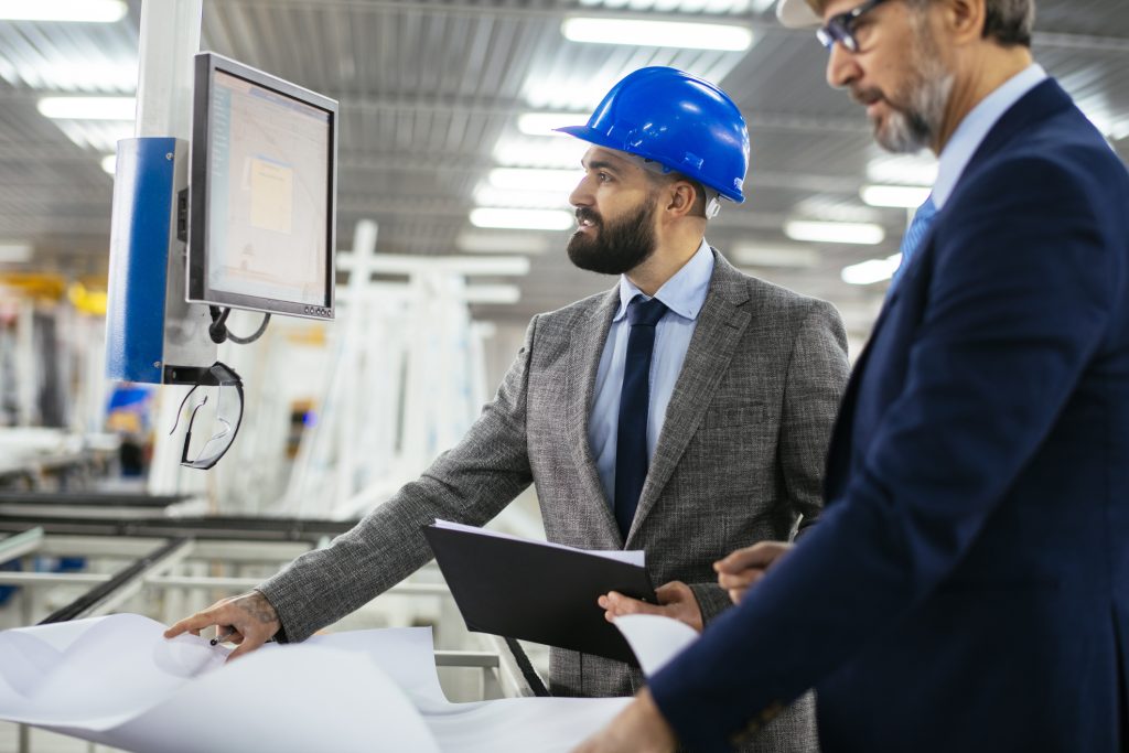 Reviewing KPIs at a computer desk in a factory.